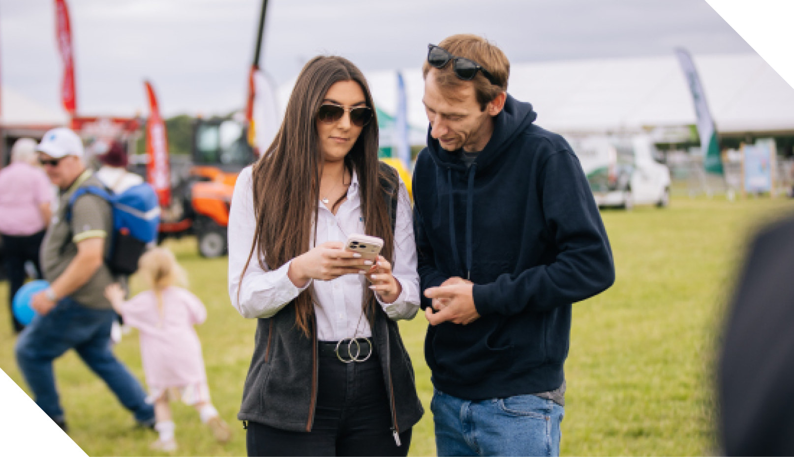 Two visitors looking at a phone at a show